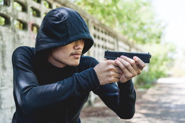 Robber assassin crime with hood points the gun already shoot