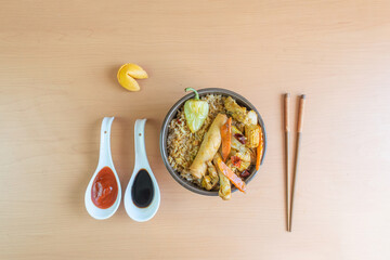 gourmet chinese food with chopsticks. in bowl with fried rice, chicken, vegetables, chun kun, soy sauce and siracha sauce
