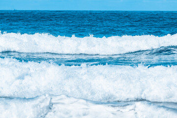 Water wave splash on blue sea background.