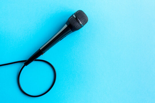 Microphone on a colorful blue background close up. Singing, writing music, karaoke online, creativity, vocals concept, symbol. Singing lessons
