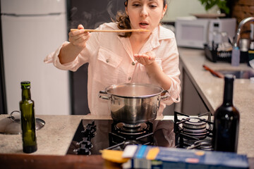 Woman tasting food from the pan