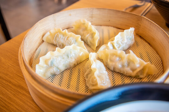 Close up image of Korean style steamed dumplings on a bamboo steamer