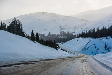 Fototapeta na wymiar Road through mountains and trees somewhere near Jasper. Alberta, Canada.