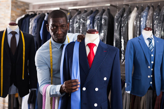 Seller is demonstrating jacket and tie in store. High quality photo