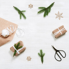 Preparing handmade Christmas gift and present for friends or family for Christmas and New Year. Fir branch, spruce branches, ribbon, thread, scissors