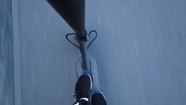 Ride with an e-scooter over asphalt with a view down