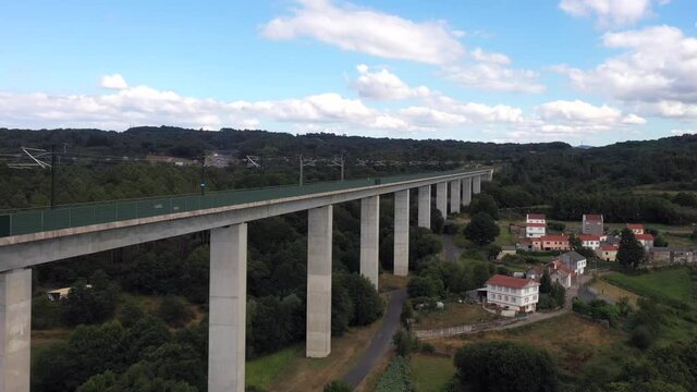 Empty Railway Bridge Spanning Across The Green Landscape In Botos, Spain At Daytime - aerial drone