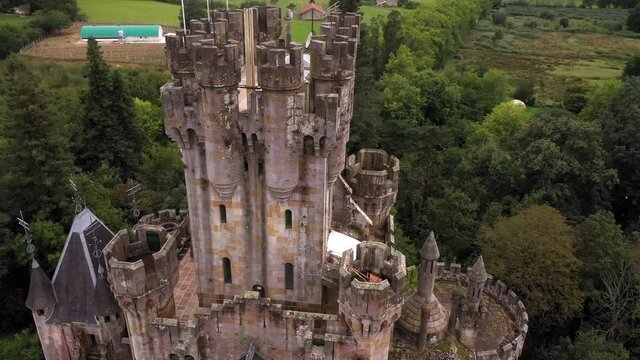 Close up aerial of main tower from historic Butron Castle surrounded by woods