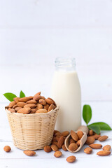 Homemade almond milk in a small bottle and almond in basket isolated on a white background, healthiest nuts and one of the best brain foods.Selective focus.