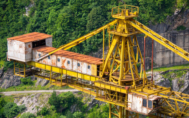 Yellow giant construction crane on the mountains hills