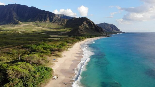 arial uprising drone on white beach, Big Island Hawaii. blue sky with clouds on a sunny day. 
no people. beautiful mountains in the distance. 4K UHD