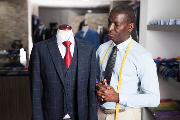 Afro-american man buyer in shirt choosing colored tie in the dress shop. High quality photo