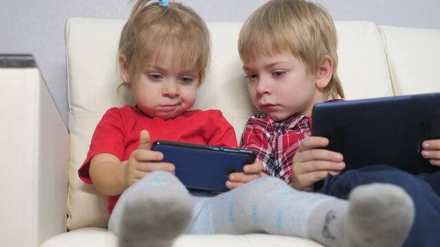 happy family teamwork kids watch online streaming video on a smartphone. lifestyle children little boy and girl brother sister watch online streaming broadcasting cartoons on the phone