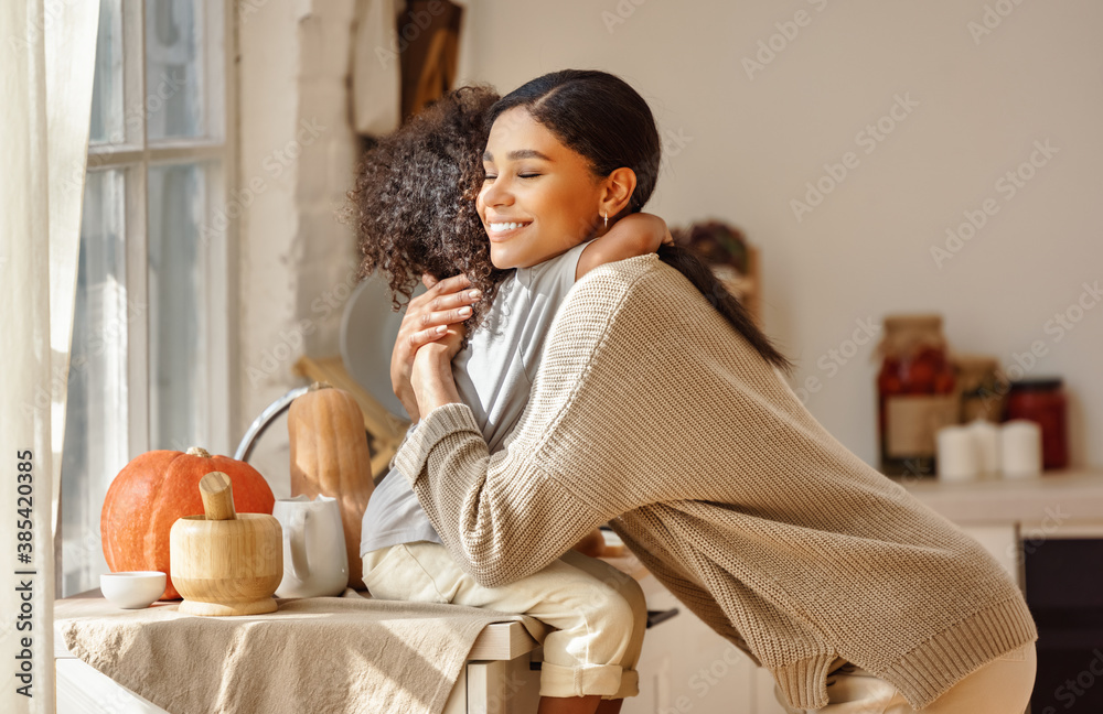 Canvas Prints happy ethnic family mother and son hugging in the kitchen at home.