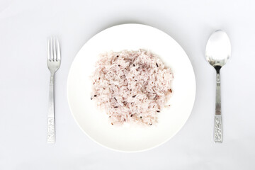 Plain rice on a white plate, Spoon, fork on white background. Top view flat lay of business restaurant and food menu
