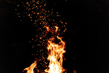 Fire in a fire pit at night. Sparkles fly high