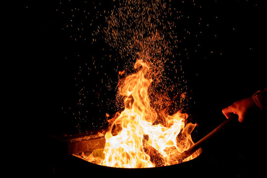 Fire in a fire pit at night. Sparkles fly high