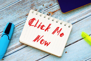 Business concept about Click Me Now with sign on the page.