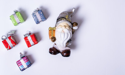 Fototapeta na wymiar Christmas composition, Santa Claus or gnome surrounded by Christmas gifts on a white background, flat lay, top view