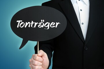 Tonträger. Mann (Anwalt) hält Schild mit Beschriftung. Sprechblase mit Text (deutsch). Hintergrund blau