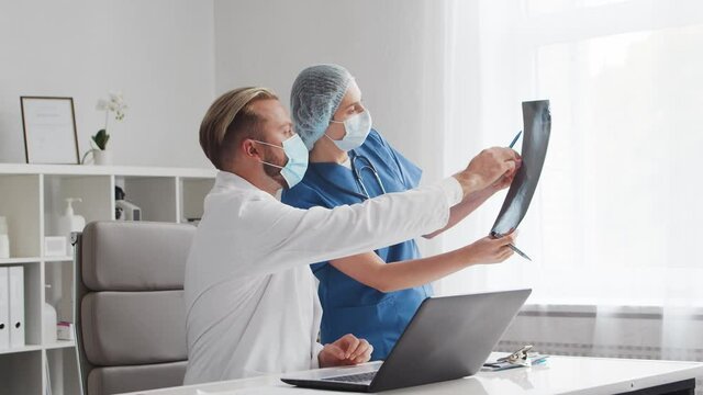 Professional medical doctors working in hospital office. Discussion with the chief physician and the young nurse.