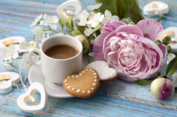 romantic breakfast: a bouquet of peonies and jasmine, a cup of coffee, cookies and heart-shaped light bulbs