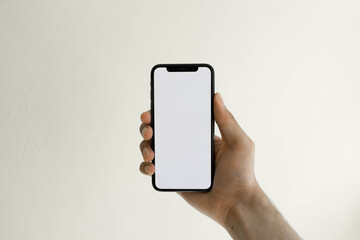 Holding phone on white background.
