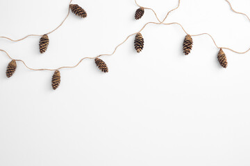 Zero waste christmas garland made from pine cone and natural jute twine. Horizontal composition, flat lay, top view. Eco friendly minimal christmas top mockup. © Breezze