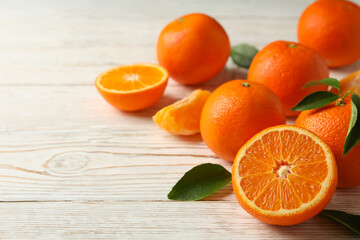 Ripe sweet mandarins on white wooden background, space for text
