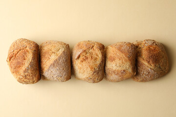 Fresh baked buns on beige background, top view