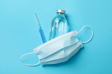 Medical mask and medicines on blue background