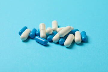 Obraz na płótnie Canvas Pills capsules on blue background, space for text