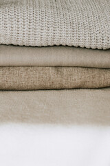 Background with warm sweaters. Heap of knitted clothes warm background, knitwear, place for text, autumn-winter concept. Copy space.