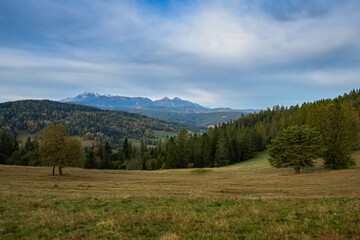 Panorama of wild nature in autumn. Blue skies over the snowy mountain and colorful trees. Autumn landscape, Slovakia.