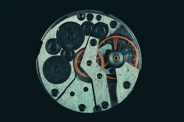 Old clockwork mechanism in close-up. Selective focus on macro details. Light vintage toning. Grunge style backdrop