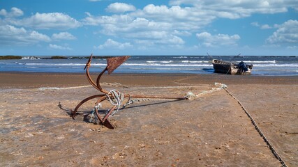 Anchor and fishing boat by the sea