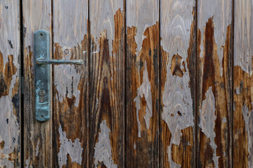 old and weathered wooden door with metal keyhole, closed gate with space for text and no person