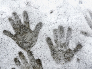   child hand prints in the snow. The impact of human heat on snow. A handprints on a slightly melted snow,  concept  beginning of winter  . selective focus