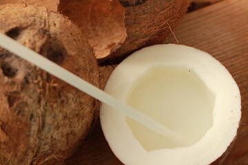 a sliced coconut with coconut milk in a glass