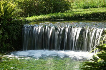 Small artificial waterfall in the Ninfa Garden in Italy