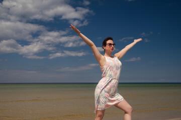 Fototapeta premium young happy girl in summer dress by the sea