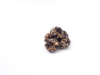 Pile of black sesame and almond cereal ball isolated on a white background.