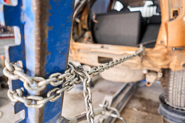 A broken car with a violation of geometry is on the stocks for leveling. Restoration of vehicles with chain and hook. Repair in the workshop and auto