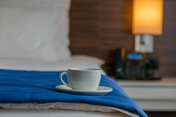 Cup of coffee on hotel bed