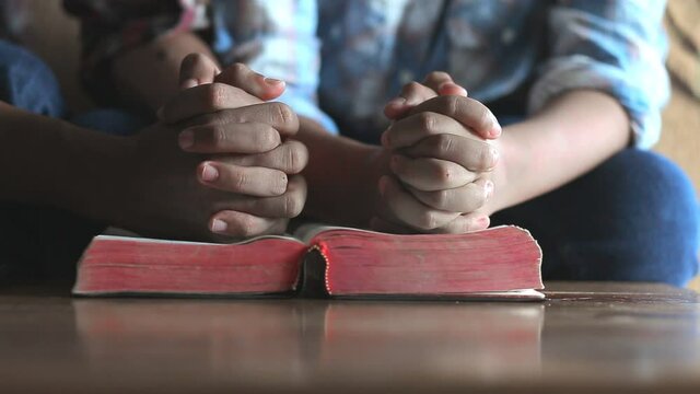 Close up hands praying on the bible, Home church father and son, Religion concept.