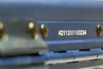 Laser engraved serial number on blue aluminum surface