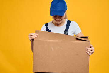 Working woman in uniform box in hands delivery courier service rendering yellow background