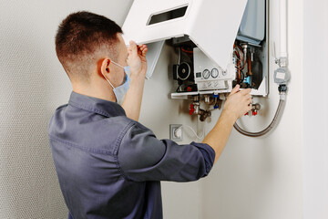 Obraz premium a man repairing a boiler in a medical mask