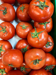 Fresh tomatoes are arranged for background design. Piles of fresh fruit to create designs about agriculture, food, nature, & healthy living.