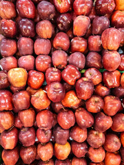 Apples are arranged for background design. Piles of fresh fruit to create designs about agriculture, food, nature, & healthy living.